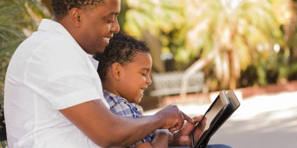Père et fils consultant Airmes sur leur tablette