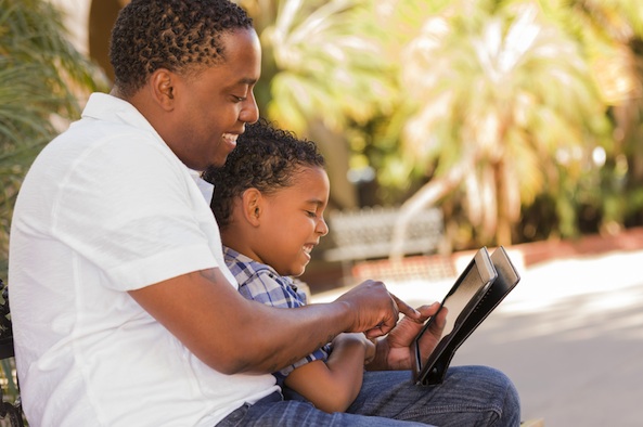 Père et fils consultant Airmes sur leur tablette